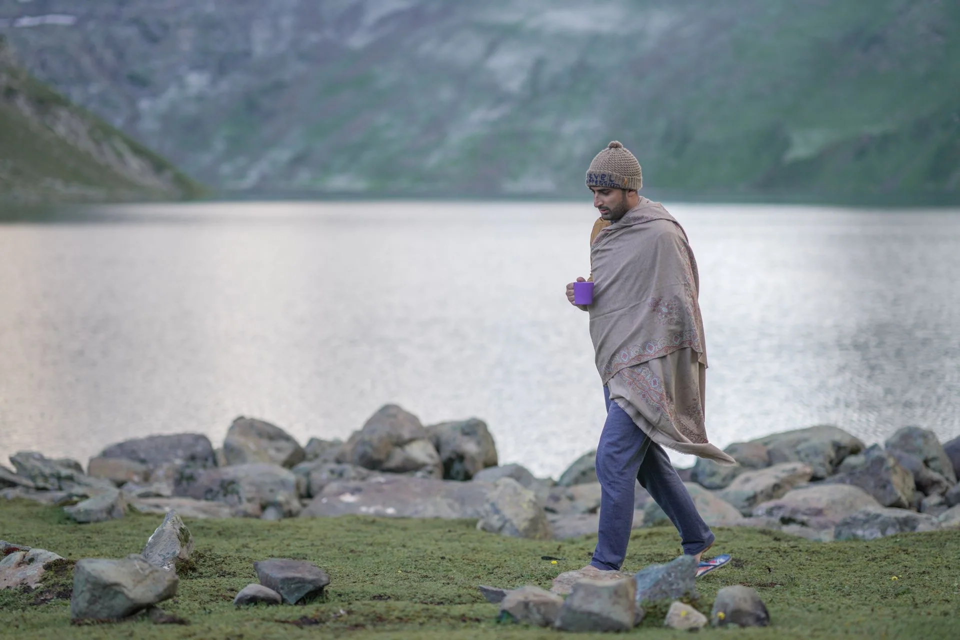 An adult walking along a quiet lakeside path