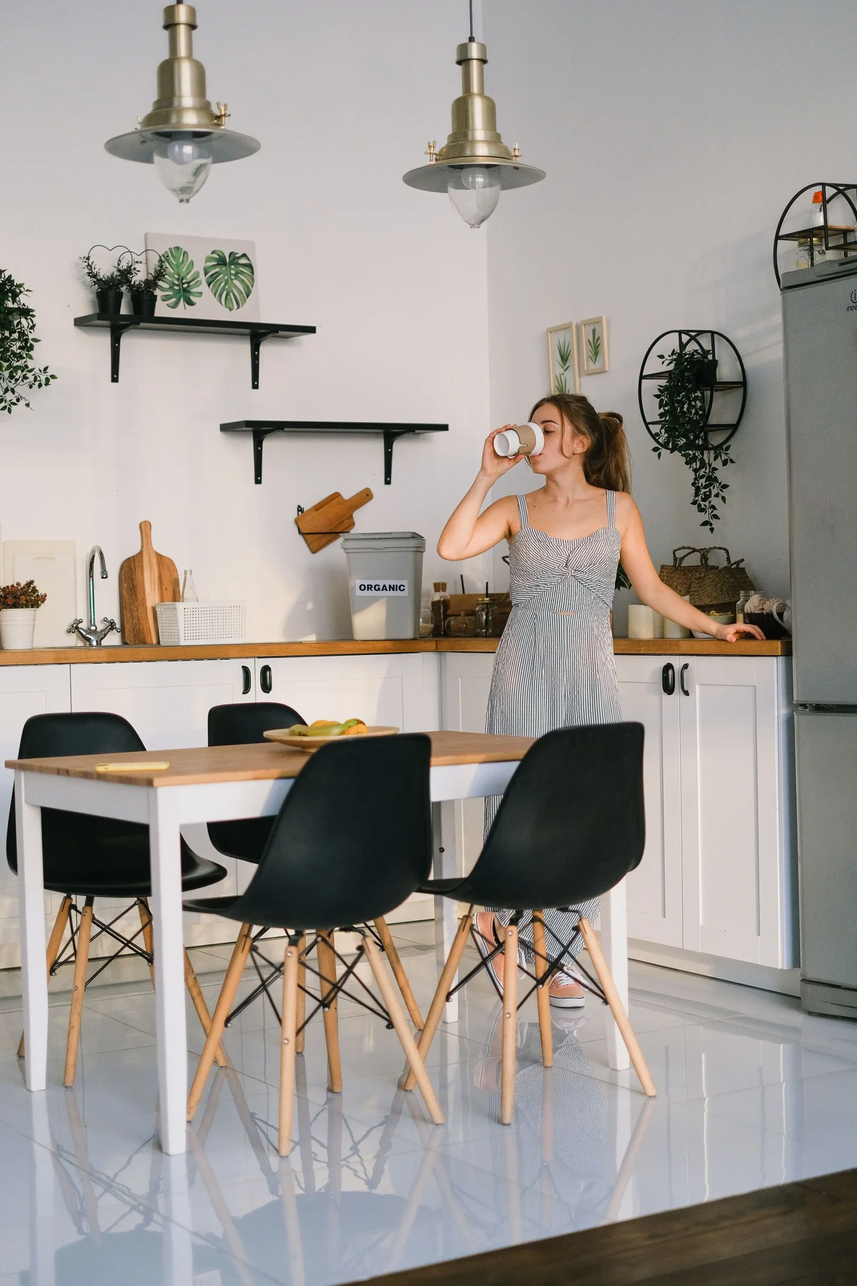 An adult enjoying a quiet morning drink in a kitchen