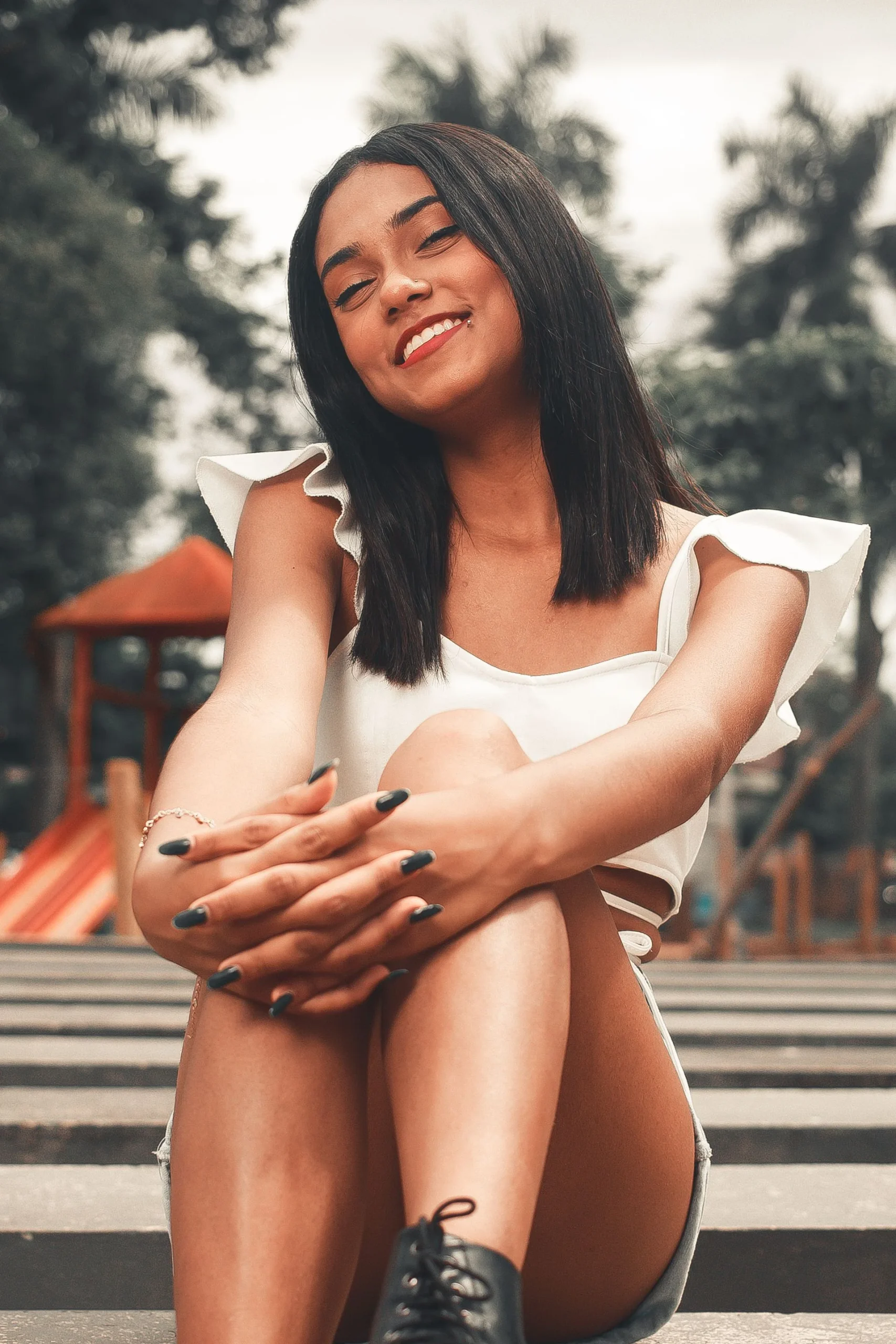 An adult smiling outdoors in soft afternoon light